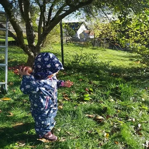 Ein Kind entdeckt spielerisch die Natur im Gartenbereich der Tagesmutter am Brudergrund in Erbach.