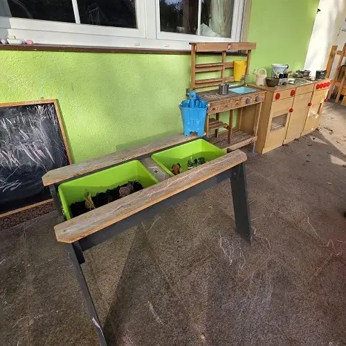 Kreativer Außenbereich mit Spiel- und Bastelstation der Kindertagespflege Kunterbunt am Brudergrund