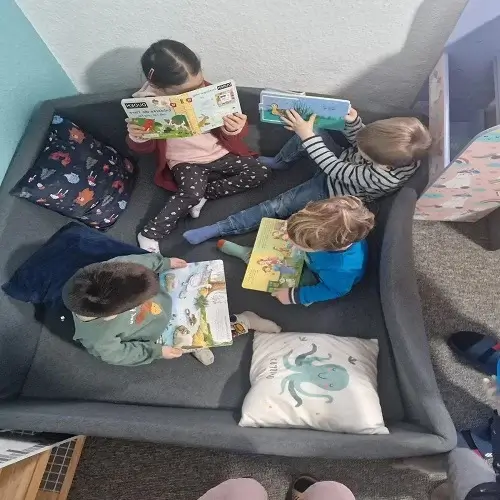 Kinder lesen gemeinsam Bücher in der Leseecke der Kindertagespflege Kunterbunt am Brudergrund